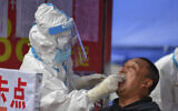 In this May 17, 2020, photo released by Xinhua News Agency, a medical worker collects sample for COVID-19 testing at the Tongji community in Shulan in northeastern China's Jilin Province. Authorities have tightened restrictions in parts of Jilin province in response to a local cluster. (Zhang Nan/Xinhua via AP)