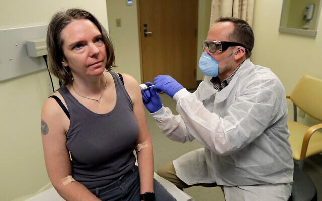 In this March 16, 2020, file photo, a pharmacist gives Jennifer Haller, left, the first shot in the first-stage safety study clinical trial of a potential vaccine for COVID-19, the disease caused by the new coronavirus, at the Kaiser Permanente Washington Health Research Institute in Seattle. The vaccine by Cambridge, Massachusetts-based Moderna Inc., generated antibodies similar to those seen in people who have recovered from COVID-19 in a study volunteers who were given either a low or medium dose. (AP Photo/Ted S. Warren, File) In this March 16, 2020, file photo, a pharmacist gives Jennifer Haller, left, the first shot in the first-stage safety study clinical trial of a potential vaccine for COVID-19, the disease caused by the new coronavirus, at the Kaiser Permanente Washington Health Research Institute in Seattle. The vaccine by Cambridge, Massachusetts-based Moderna Inc., generated antibodies similar to those seen in people who have recovered from COVID-19 in a study volunteers who were given either a low or medium dose. (AP Photo/Ted S. Warren, File)