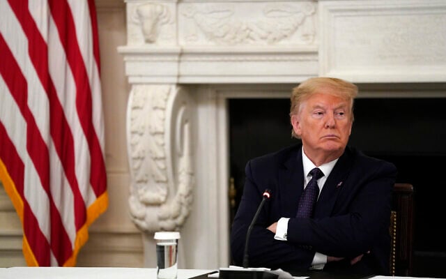 US President Donald Trump listens during a meeting with restaurant industry executives about the coronavirus response, in the State Dining Room of the White House, in Washington, May 18, 2020. (Evan Vucci/Ap) US President Donald Trump listens during a meeting with restaurant industry executives about the coronavirus response, in the State Dining Room of the White House, in Washington, May 18, 2020. (Evan Vucci/Ap)