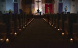 ILLUSTRATIVE - In this April 11, 2020, file photo, a person films Easter Vigil Mass at St. Patrick Church in North Hollywood, California (AP Photo/Damian Dovarganes)