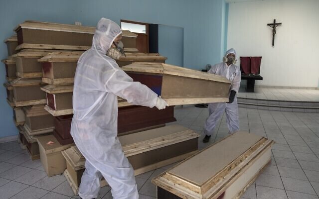 Funeral home workers prepare to load coffins into a waiting vehicle to transport to a public hospital in order to pick up bodies of deceased persons who are suspected to have died from the new coronavirus, at a crematorium in Lima, Peru. (AP Photo/Rodrigo Abd) Funeral home workers prepare to load coffins into a waiting vehicle to transport to a public hospital in order to pick up bodies of deceased persons who are suspected to have died from the new coronavirus, at a crematorium in Lima, Peru. (AP Photo/Rodrigo Abd)