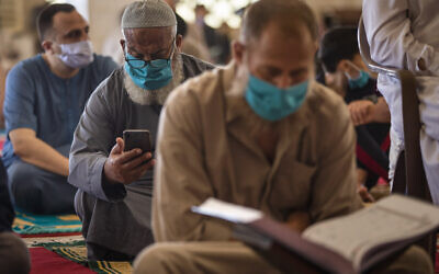 Palestinians wearing face masks read the Quran as they attend the last Friday noon Prayer of the holy month of Ramadan, in a mosque in Gaza City, May. 22, 2020. (AP Photo/Khalil Hamra) Palestinians wearing face masks read the Quran as they attend the last Friday noon Prayer of the holy month of Ramadan, in a mosque in Gaza City, May. 22, 2020. (AP Photo/Khalil Hamra)