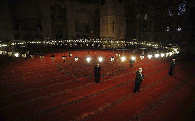 Masked people offer the Eid al-Fitr prayer amid concerns of the coronavirus outbreak at historical Suleymaniye Mosque, in Istanbul, May 24, 2020 (AP Photo/Emrah Gurel)