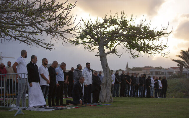 Muslim worshipers offer Eid al-Fitr prayer that marks the end of the holy fasting month of Ramadan at a park in Jaffa, May 24, 2020. (AP Photo/Oded Balilty)