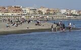 People enjoy the warm weather as they gather at Ostia beach, near Rome, Sunday, May 24, 2020. (AP Photo/Andrew Medichini)