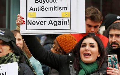 Far-right activist Laura Loomer holds up a sign emblazoned with the logo of Jewish terror group Kach, across the street from a rally organized by Women's March NYC, in New York on January 19, 2019. (AP/Kathy Willens)