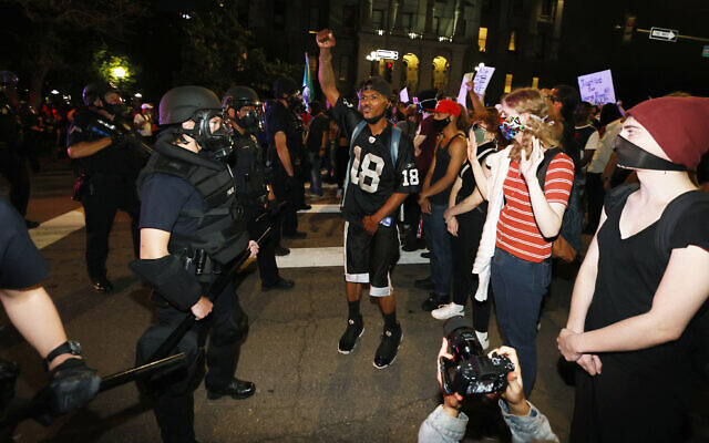 Denver police face off with protesters outside the State Capitol over the death of George Floyd, a handcuffed black man in police custody in Minneapolis, May 28, 2020, in Denver. (AP Photo/David Zalubowski) Denver police face off with protesters outside the State Capitol over the death of George Floyd, a handcuffed black man in police custody in Minneapolis, May 28, 2020, in Denver. (AP Photo/David Zalubowski)