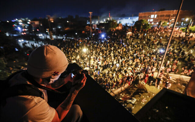 A protestor takes a picture of a demonstration from the roof of the Minneapolis 3rd Police Precinct, May 28, 2020, in Minneapolis. (AP Photo/John Minchillo) A protestor takes a picture of a demonstration from the roof of the Minneapolis 3rd Police Precinct, May 28, 2020, in Minneapolis. (AP Photo/John Minchillo)