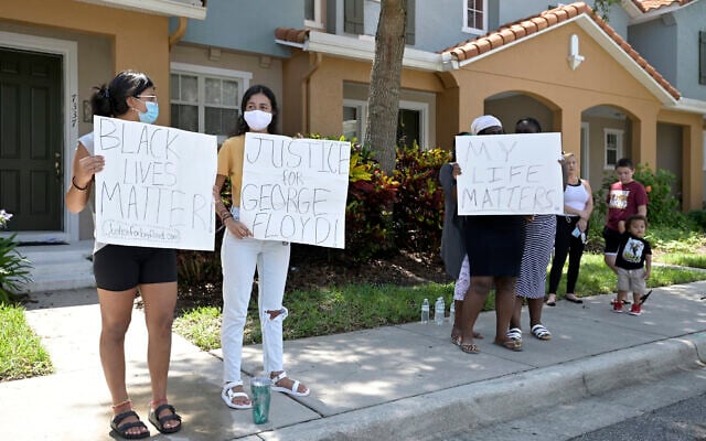 Protesters hold signs on a sidewalk across the street from a townhouse owned by Minneapolis police officer Derek Chauvin, May 29, 2020, in Windermere, Florida. (AP Photo/Phelan M. Ebenhack) Protesters hold signs on a sidewalk across the street from a townhouse owned by Minneapolis police officer Derek Chauvin, May 29, 2020, in Windermere, Florida. (AP Photo/Phelan M. Ebenhack)