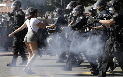A protester confronts San Jose police as they advance on May 29, 2020, in San Jose, California as people demonstrate nationwide in response to George Floyd dying while in police custody on Memorial Day, in Minneapolis. (AP Photo/Ben Margot)