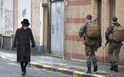 An ultra-Orthodox Jew walks past Belgian soldiers as they patrol during religious services in Antwerp, Belgium January 24, 2015. (AP Photo/Virginia Mayo)