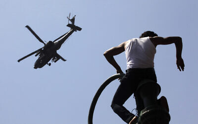 An Egyptian protester watches an Apache army helicopter is it flies over Tahrir Square, the focal point of Egyptian uprising, in Cairo Sunday, June 30, 2013.  (AP Photo/Amr Nabil)