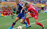 Japan's Keisuke Honda, left, and Palestine's Abdallah Jaber contest for the ball during the AFC Asia Cup soccer match between Japan and Palestine in Newcastle, Australia, January 12, 2014. (Rob Griffith/AP)