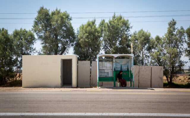Illustrative: A woman waits at a bus stop near a public bomb shelter, by the southern kibbutz of Kfar Aza on July 06, 2015. (Miriam Alster/FLASH90)