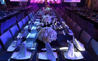 Tables at an event hall set out for a wedding. (Yaakov Naumi/Flash90)