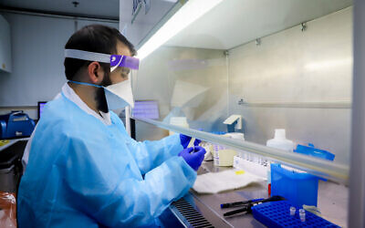 Illustrativeechnicians carry out a diagnostic test for coronavirus in a lab at the Rambam Hospital in Haifa, on March 17, 2020. (Yossi Aloni/Flash90)