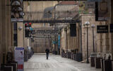 People walk past closed stores in the empty Mamilla Mall in Jerusalem, during a COVID-19 lockdown on March 23, 2020. (Nati Shohat/Flash90)