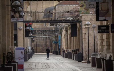 People walk past closed stores in the empty Mamilla Mall in Jerusalem, during a COVID-19 lockdown on March 23, 2020. (Nati Shohat/Flash90)
