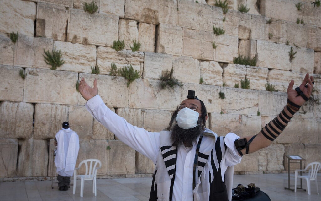 An ultra-Orthodox man, masked amid the COVID-19 crisis, gestures near the Western Wall in Jerusalem's Old City. April 19, 2020. (Nati Shohat/Flash90) An ultra-Orthodox man, masked amid the COVID-19 crisis, gestures near the Western Wall in Jerusalem's Old City. April 19, 2020. (Nati Shohat/Flash90)