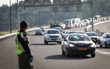 A police officer stands guard at a roadblock on a road leading to Ein Hemed, near Jerusalem, on April 28, 2020 (Nati Shohat/Flash90)
