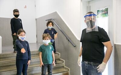Israeli students  wear protective face masks as they return to school for the first time since the outbreak of the coronavirus, May 3, 2020 in Jerusalem. (Olivier Fitussi/Flash90)