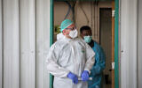 Medical workers wearing protective clothing as they stand outside the coronavirus unit at Shaare Zedek Medical Center in Jerusalem,  May 5, 2020. (Nati Shohat/Flash90)