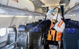 A worker wearing protective clothing disinfects andIsrair plane after its arrival from Moscow at the Ben Gurion International Airport, May 5, 2020. (Yossi Zeliger/Flash90)