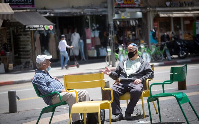 People wear protective face masks as they shop at the Carmel market in Tel Aviv before it officially opens up to the public, May 6, 2020. (Miriam Alster/FLASH90)