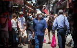 People shop at the Carmel Market in Tel Aviv on May 8, 2020. (Miriam Alster/Flash90)
