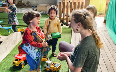 Children and a teacher at a kindergarten in Tel Aviv as they return on May 10, 2020, for the first time in two months after shut down to prevent the spread of the coronavirus. (Avshalom Sassoni/Flash90)
