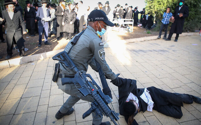 Ultra Orthodox men clash with police officers during the celebrations of the Jewish holiday of Lag B'Omer on Mt. Meron in northern Israel on May 12, 2020. (David Cohen/Flash90) Ultra Orthodox men clash with police officers during the celebrations of the Jewish holiday of Lag B'Omer on Mt. Meron in northern Israel on May 12, 2020. (David Cohen/Flash90)