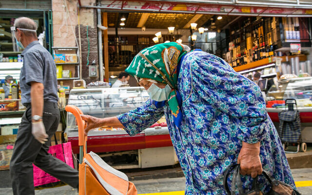 People shop in the Mahane Yehuda market in Jerusalem after it reopens, May 12, 2020. (Olivier Fitoussi/Flash90) People shop in the Mahane Yehuda market in Jerusalem after it reopens, May 12, 2020. (Olivier Fitoussi/Flash90)