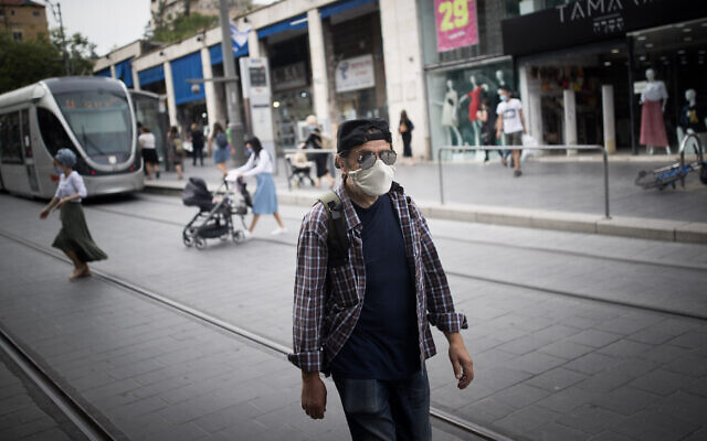 A man wearing a face mask walks on Jaffa Street in downtown Jerusalem on May 13, 2020. (Yonatan Sindel/Flash90) A man wearing a face mask walks on Jaffa Street in downtown Jerusalem on May 13, 2020. (Yonatan Sindel/Flash90)
