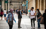 A security guard asks people to put on face masks at the Mamilla Mall near Jerusalem's Old City, on May 14, 2020. (Olivier Fitoussi/Flash90)
