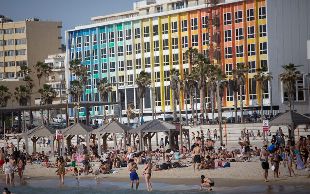 Defying COVID-19 restrictions, Israelis enjoy the beach in Tel Aviv, as temperatures rise to 40 degrees in some parts of the country, May 16, 2020. (Miriam Alster/Flash90)
