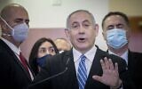 Prime Minister Benjamin Netanyahu is surrounded by Likud lawmakers as he gives a press statement ahead of the start of his trial at the District Court in Jerusalem, May 24, 2020. (Yonatan Sindel/Flash90)