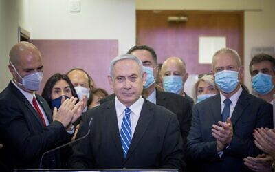 Prime Minister Benjamin Netanyahu is surrounded by Likud lawmakers as he gives a press statement ahead of the start of his trial at the Jerusalem District Court, May 24, 2020 (Yonatan Sindel/Flash90)