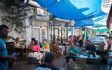 People sitting at a restaurant at the Carmel market in Tel Aviv on May 26, 2020. (Miriam Alster/FLASH90)