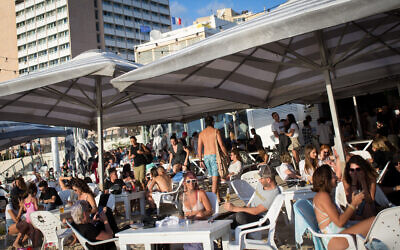 Israelis enjoy the beach in Tel Aviv on May 29, 2020. (Miriam Alster/Flash90)