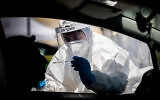 Magen David Adom medical workers perform coronavirus tests at a drive-through testing site in Jerusalem on May 30, 2020. (Yonatan Sindel/Flash90)