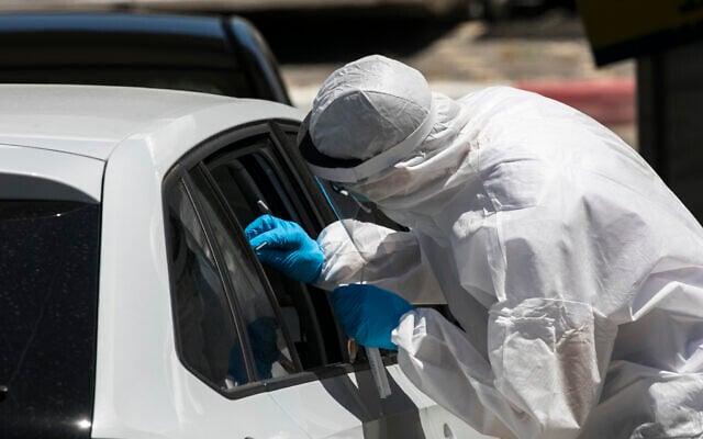 Magen David Adom medical workers test Israelis for the coronavirus at a drive-through site in Jerusalem on May 31, 2020. (Olivier Fitoussi/Flash90) Magen David Adom medical workers test Israelis for the coronavirus at a drive-through site in Jerusalem on May 31, 2020. (Olivier Fitoussi/Flash90)