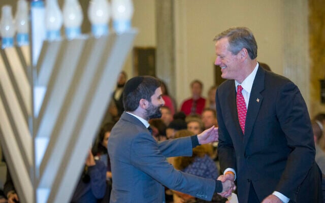 Illustrative: Rabbi Mayer Zarchi, left, shakes hands with Massachusetts Governor Charlie Baker prior to the ceremonial lighting of a Hanukkah menorah at the Massachusetts State House in Boston on December 23, 2019. (Nic Antaya for The Boston Globe via Getty Images) Illustrative: Rabbi Mayer Zarchi, left, shakes hands with Massachusetts Governor Charlie Baker prior to the ceremonial lighting of a Hanukkah menorah at the Massachusetts State House in Boston on December 23, 2019. (Nic Antaya for The Boston Globe via Getty Images)