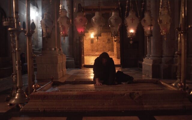 Woman at the Stone of Unction in the Church of the Holy Sepulchre, as seen in 'Holy Fire" documentary film. (Cistern Films)