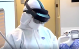 A nurse wearing protective gear and a pair of Microsoft HoloLens 2 glasses uses augmented reality functionality to perform maintenance tasks in Sheba Medical Center's "hospital room of the future" (courtesy of Sheba Medical Center)