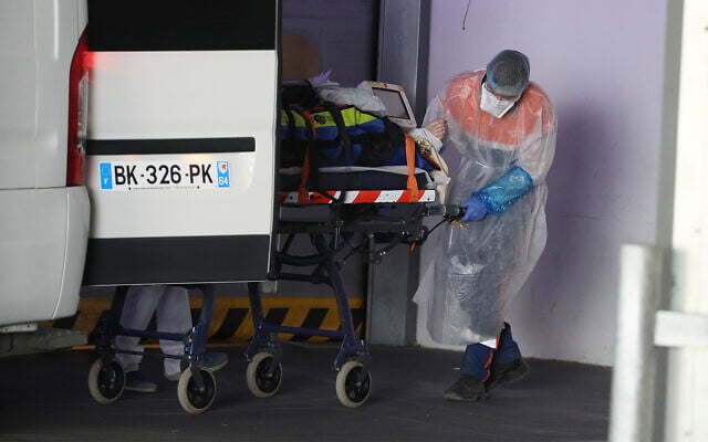 Illustrative: A medical worker pulls a patient from an ambulance in a hospital in Rennes, western France April 1, 2020. (AP/David Vincent) Illustrative: A medical worker pulls a patient from an ambulance in a hospital in Rennes, western France April 1, 2020. (AP/David Vincent)