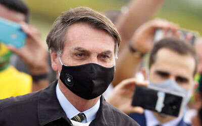 Brazil's President Jair Bolsonaro stands amid supporters taking pictures with cell phones as he leaves his official residence of Alvorada palace in Brasilia, Brazil, May 25, 2020. (AP/Eraldo Peres)