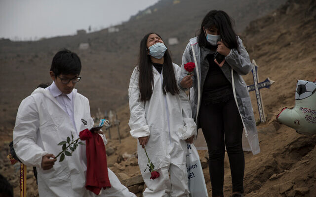 Children bury their father, who died from COVID-19 complications, at the Nueva Esperanza cemetery on the outskirts of Lima, Peru, May 28, 2020. (AP/Rodrigo Abd) Children bury their father, who died from COVID-19 complications, at the Nueva Esperanza cemetery on the outskirts of Lima, Peru, May 28, 2020. (AP/Rodrigo Abd)