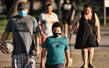 People wearing masks exercise around a track in Los Angeles, May 9, 2020. (AP/Richard Vogel)