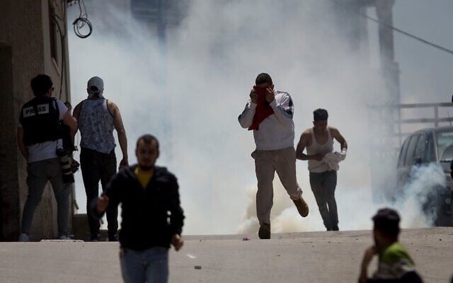 Palestinians run from tear gas fired by Israeli soldiers during clashes in the village of Yabad in the West Bank, May 12, 2020. (AP/Majdi Mohammed) Palestinians run from tear gas fired by Israeli soldiers during clashes in the village of Yabad in the West Bank, May 12, 2020. (AP/Majdi Mohammed)