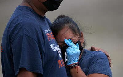 A couple mourns a loved one at the newly constructed Valle de Chalco Municipal Cemetery, built to accommodate the rise in deaths amid the coronavirus pandemic, on the outskirts of Mexico City, May 21, 2020. (AP/Marco Ugarte)